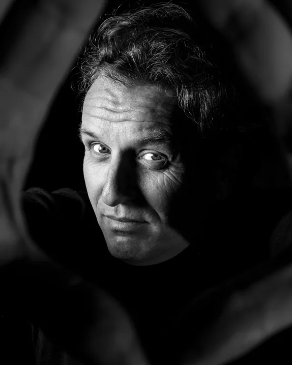 A man framed by his own hands, black and white
