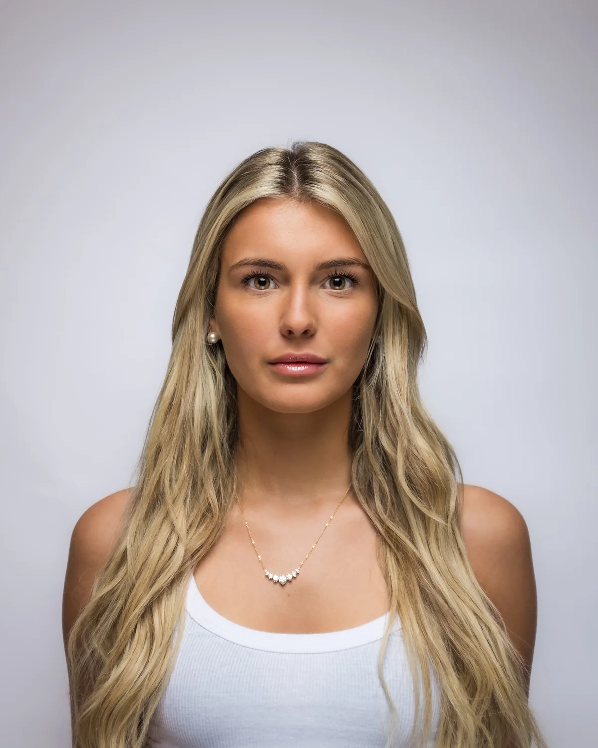 A woman with long fair hair on a grey backdrop, classic light